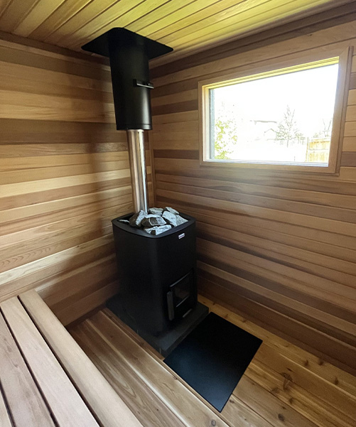 interior of outdoor sauna with wood burning stove